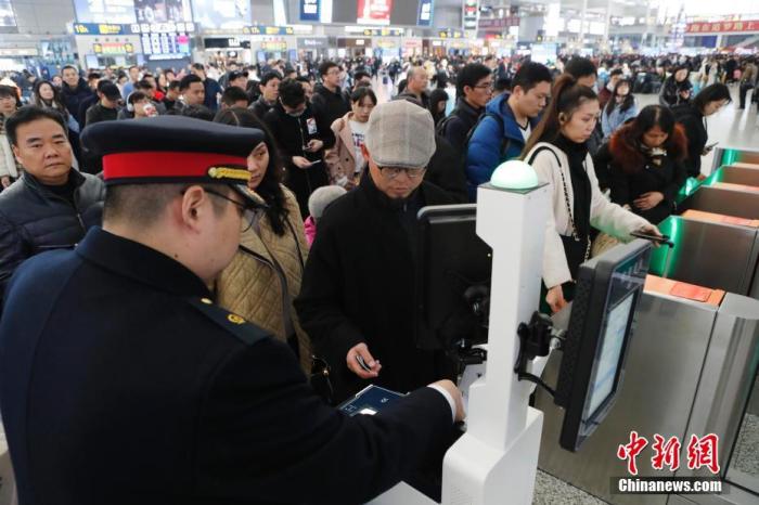 资料图：12月12日，旅客在铁路上海虹桥站排队刷身份证进站。殷立勤 摄
